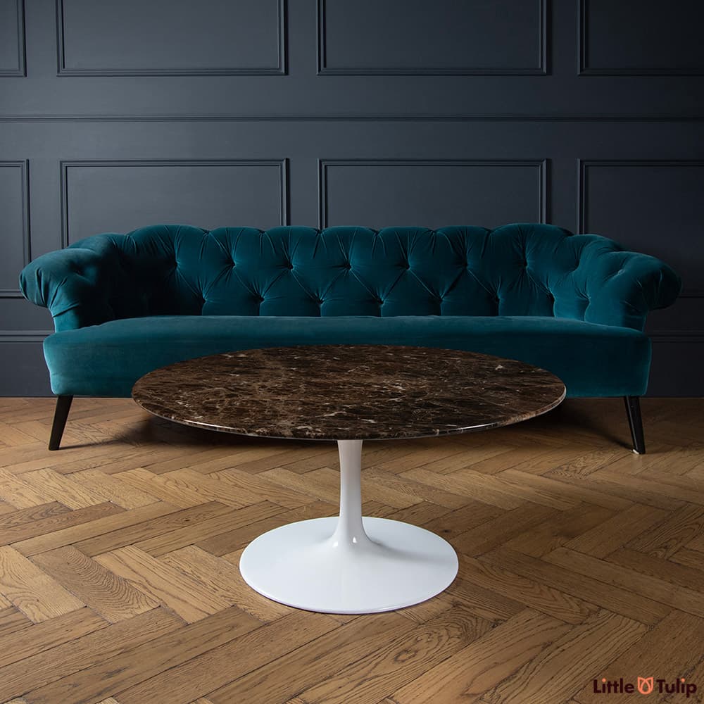 The glassy look from this beautiful Emperador Saarinen round coffee table bounces off the walnut parquet flooring.
