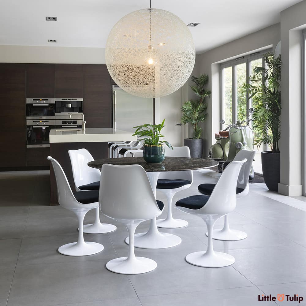 In this open kitchen space, this 120 emperador tulip table and 6 side chairs with black cushions snuggles comfortably