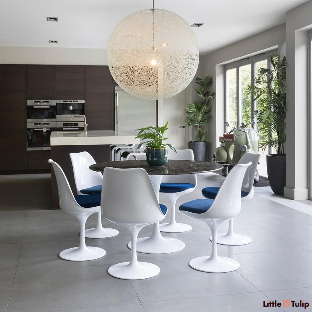 In this open kitchen space, this 120 emperador tulip table and 6 side chairs with blue cushions snuggles comfortably