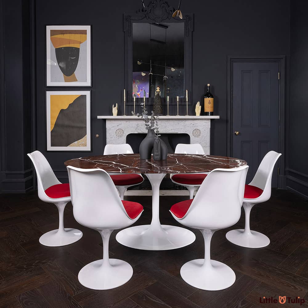 170 levanto rosso Saarinen oval dining table and 6 Tulip side chairs and red cushions add colour to this dark-themed room