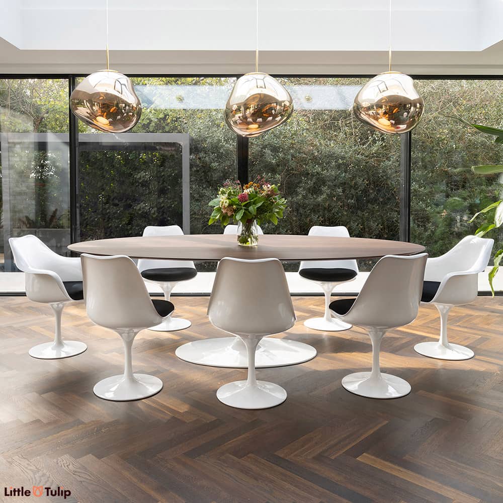 Walnut floor and walnut 244 Tulip table top contrast with white chairs and black cushions, creating two distinct levels