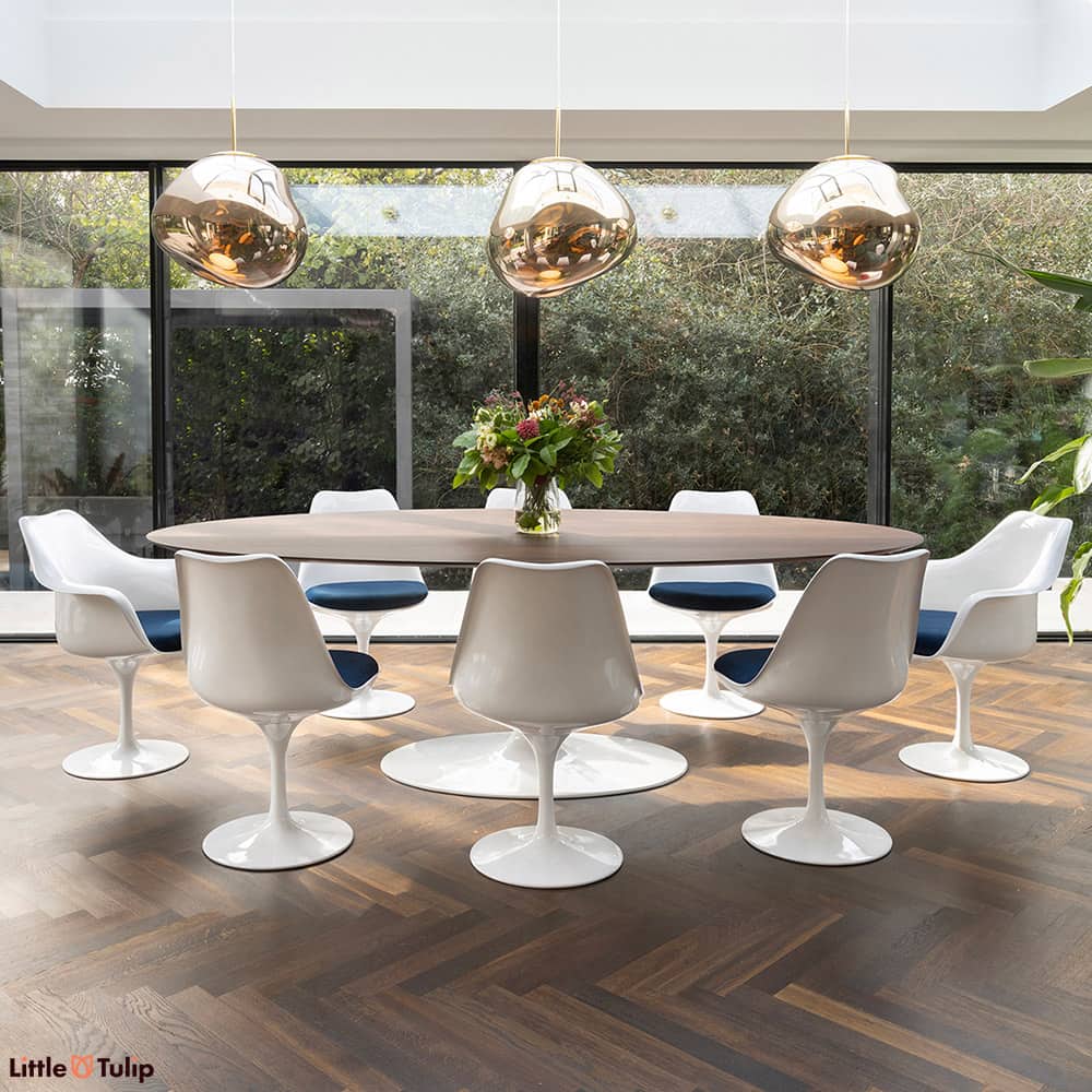 Walnut floor and walnut 244 Tulip table top contrast with white chairs and blue cushions, creating two distinct levels