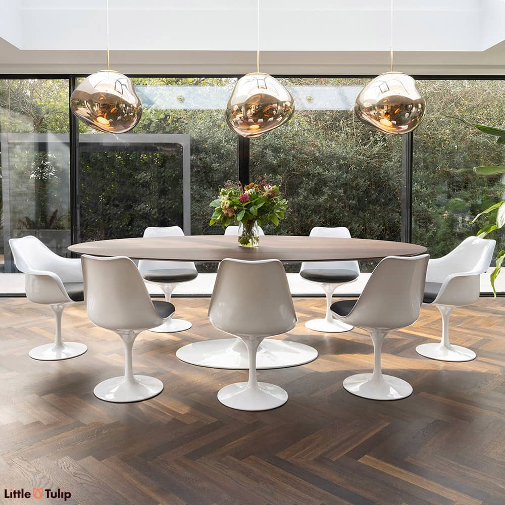 Walnut floor and walnut 244 Tulip table top contrast with white chairs and grey cushions, creating two distinct levels