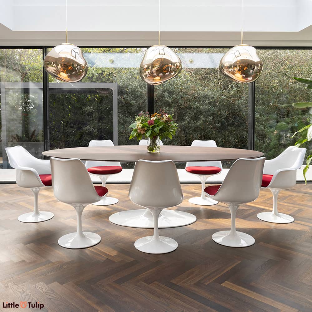 Walnut floor and walnut 244 Tulip table top contrast with white chairs and red cushions, creating two distinct levels
