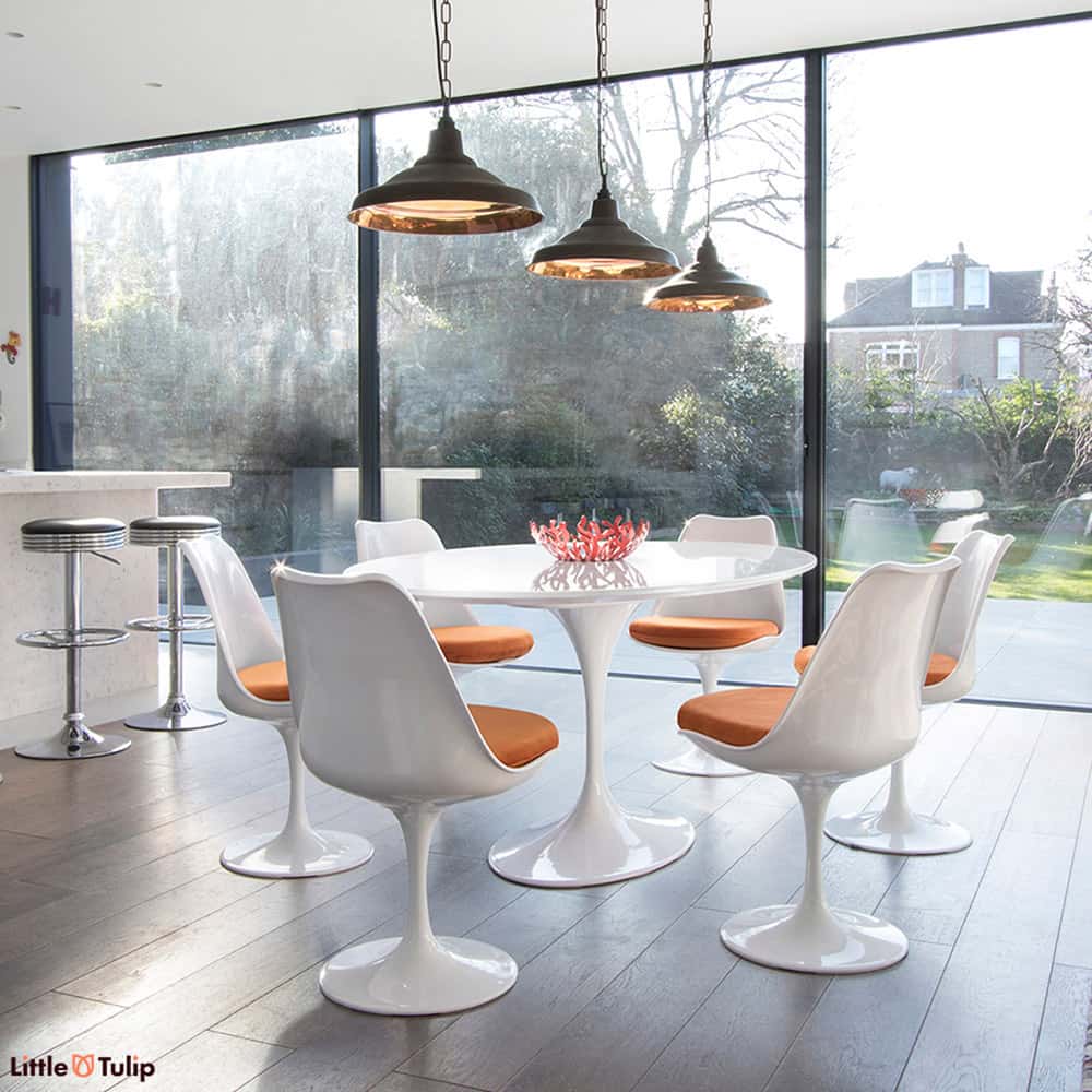 A 170 cm Oval Tulip Table in the classic white gives a room more light, more visual space & coupled with 6 Tulip chairs in orange fabric, real theatre too
