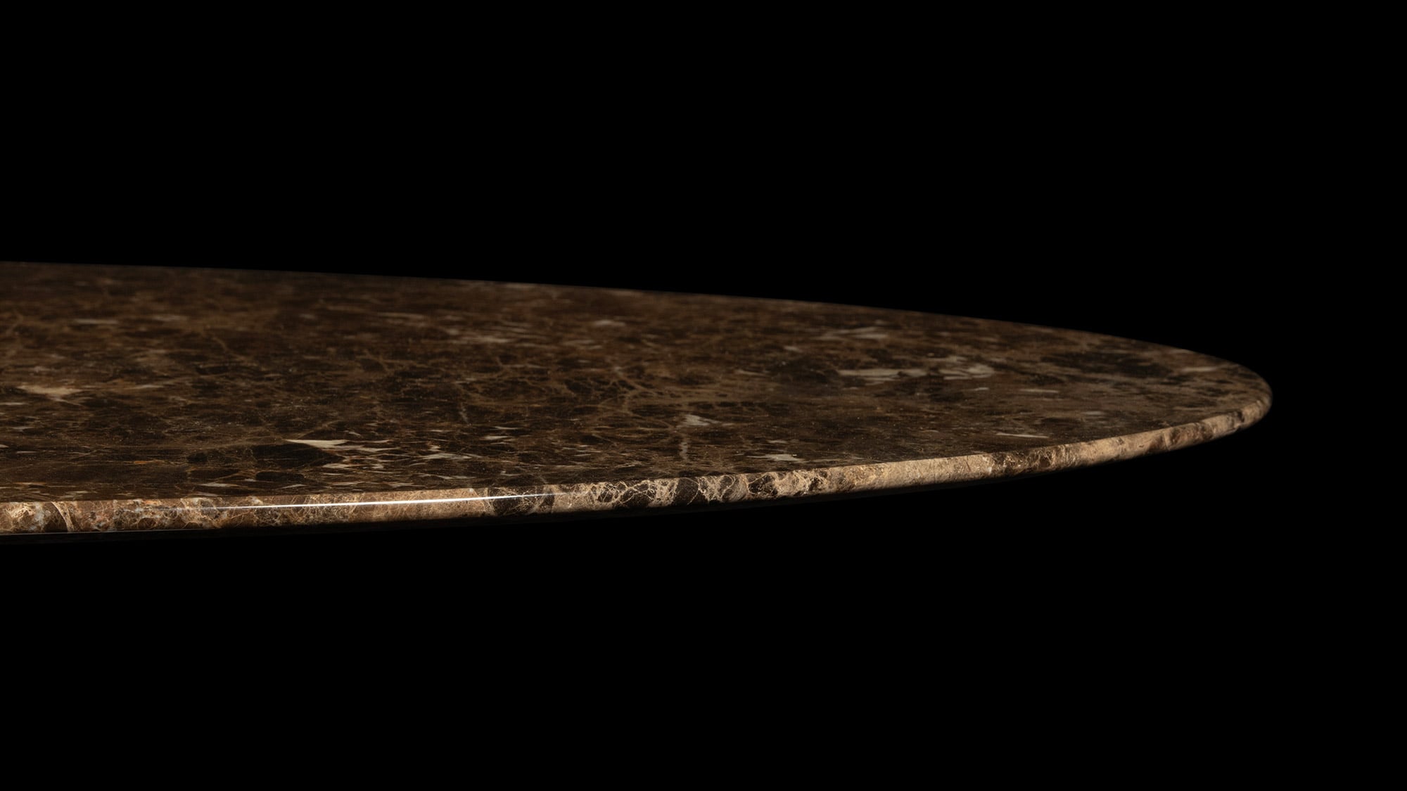 The majestic brown Emperador Marble Table top, captured under a perfect glimmer of light, highlighting its natural wonder, all atop a black backdrop