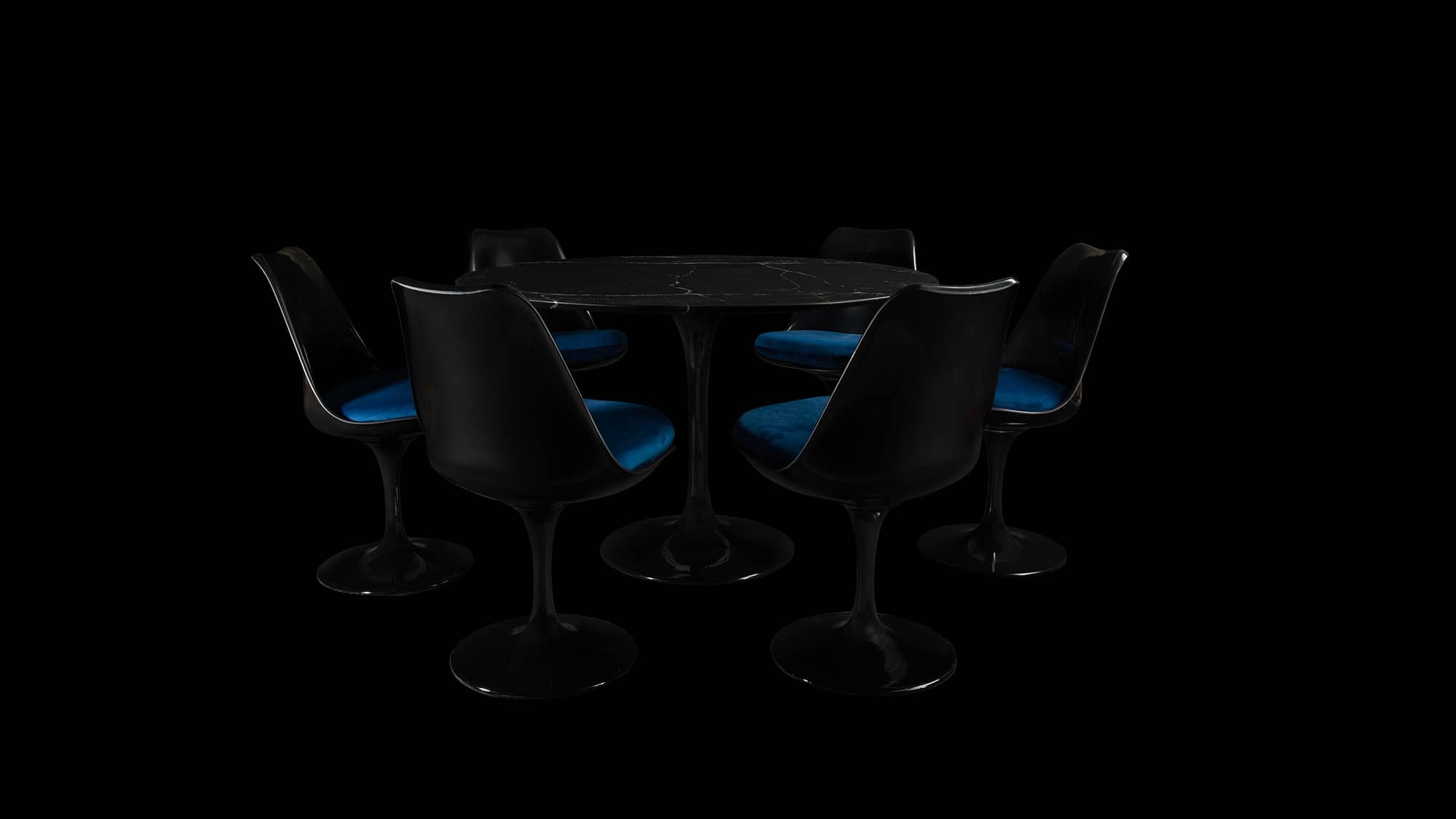 With minimal lighting, a Saarinen Tulip Table in black Marble together with 6 matching Tulip Chairs is barely visible against the black light and backdrop