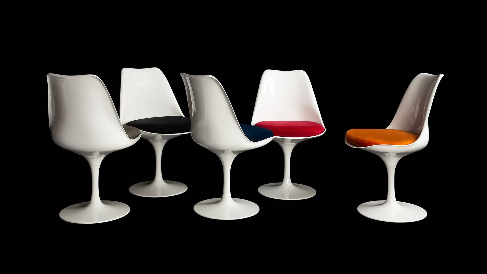 The Little Tulip Shop is the home of the Saarinen Tulip Side Chair, seen here in white with 5 different coloured chair cushions against black backdrop