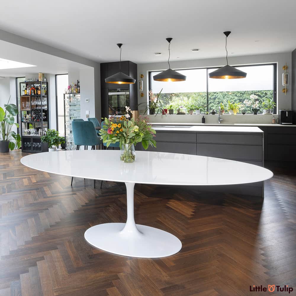 The largest oval 244 cm tulip table in white laminate look amazing as a statement in any décor and stands out here within a kitchen dining setting