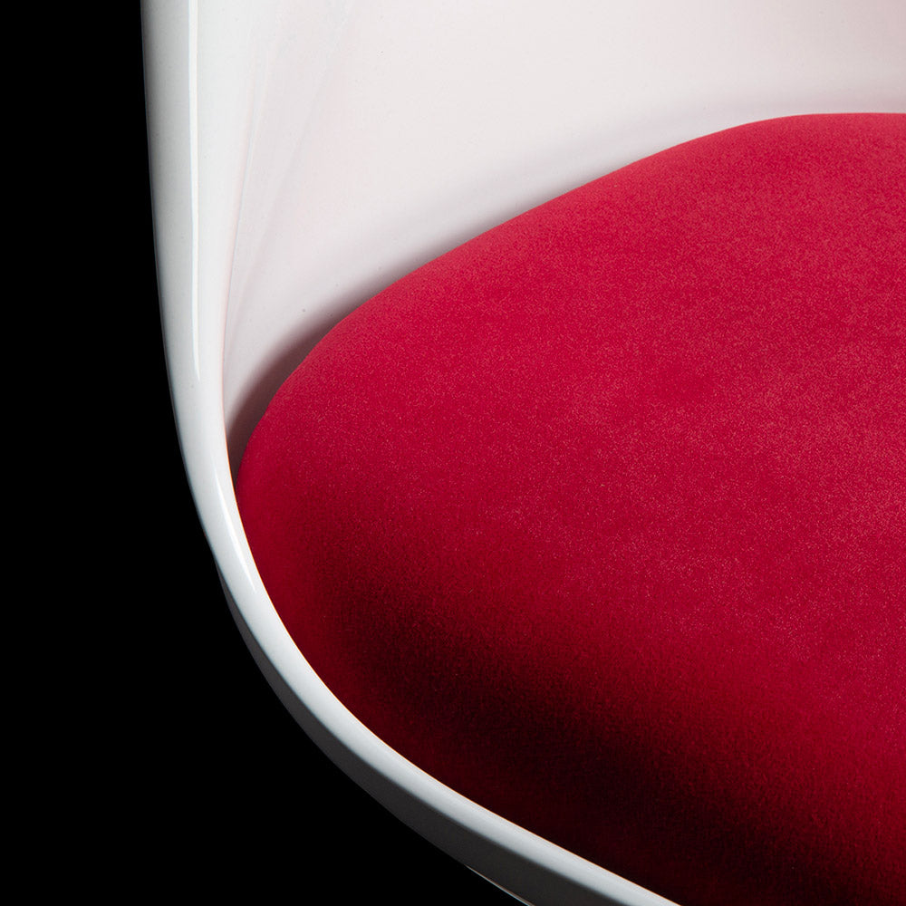 The white Tulip Chair stands out from the backdrop and you can follow the curves as the back rest flows into the seat, broken with the red of the seat pad