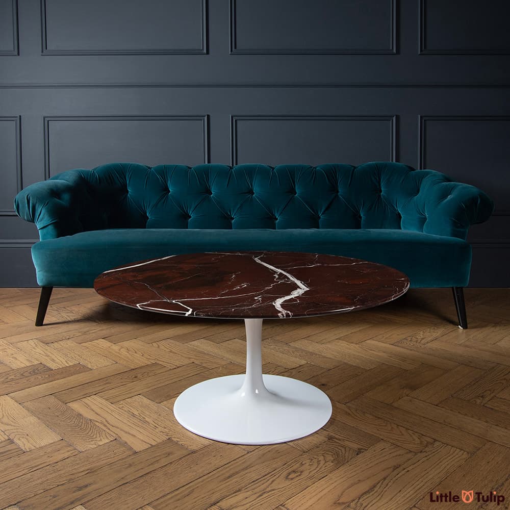 A refined feel is achieved with the lavish levanto rosso Saarinen circular coffee table elevating the dark themed room.