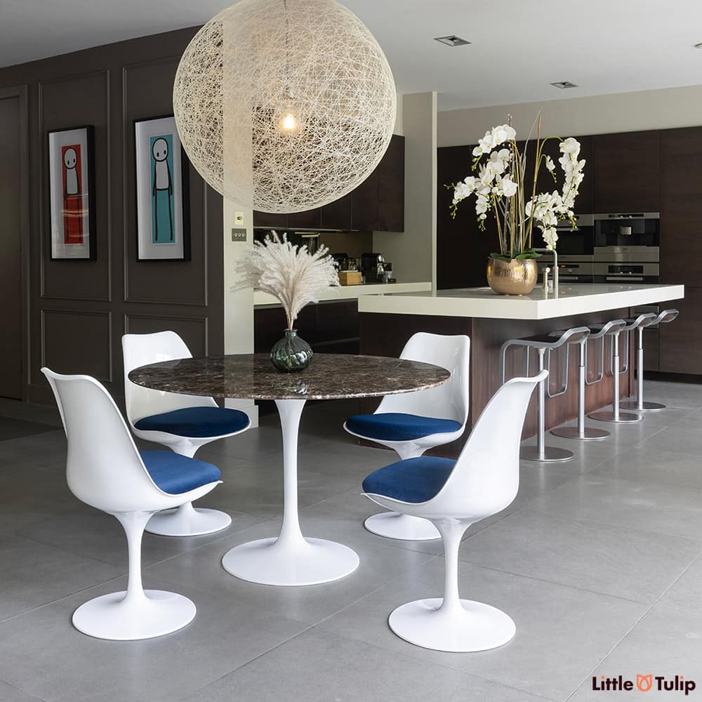 On the edge of the kitchen but still the defining piece is the 120 emperador tulip table with 4 side chairs blue cushions
