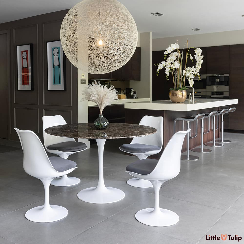 On the edge of the kitchen but still the defining piece is the 120 emperador tulip table with 4 side chairs grey cushions