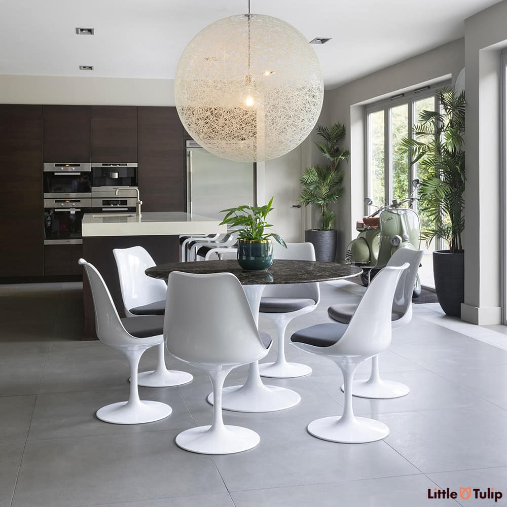 In this open kitchen space, this 120 emperador tulip table and 6 side chairs with grey cushions snuggles comfortably