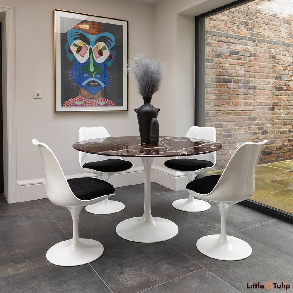 Centre shot you will find the 120 Saarinen round levanto rosso dining table and 4 Tulip side chairs with black cushion