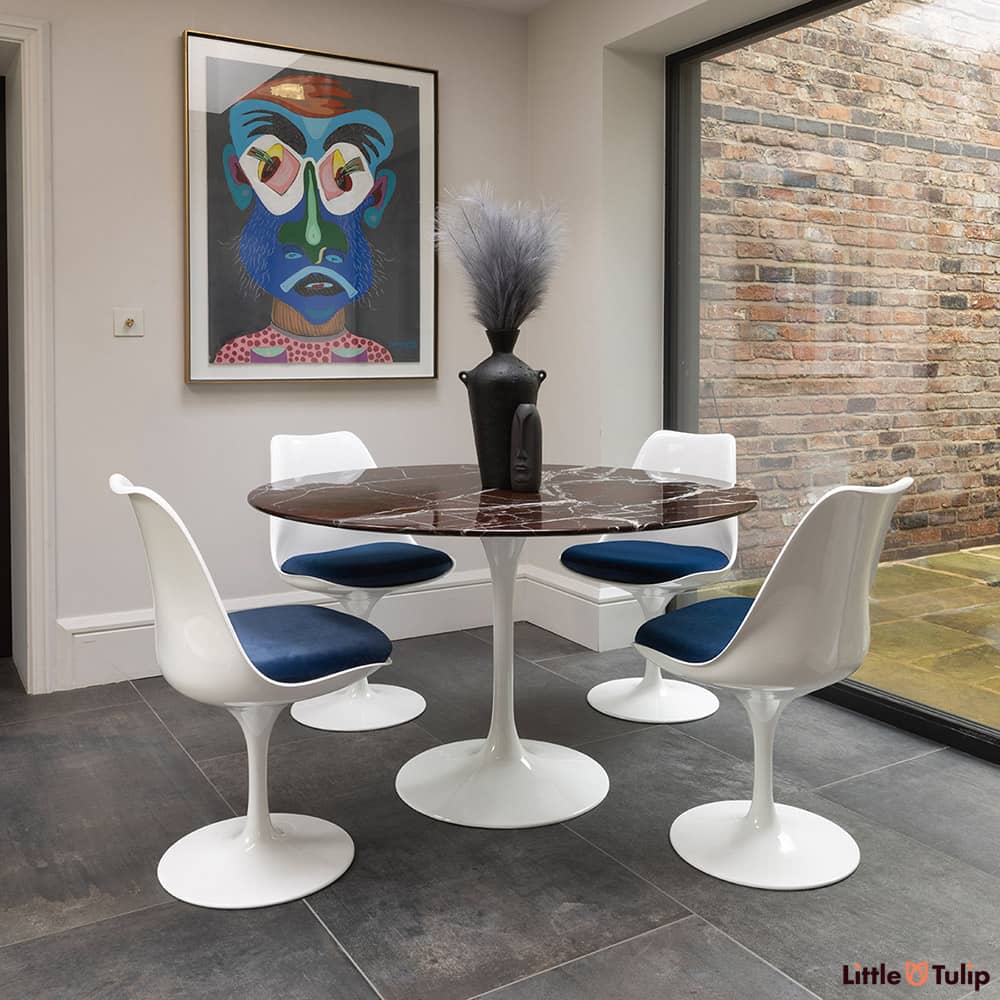 Centre shot you will find the 120 Saarinen round levanto rosso dining table and 4 Tulip side chairs with blue cushion