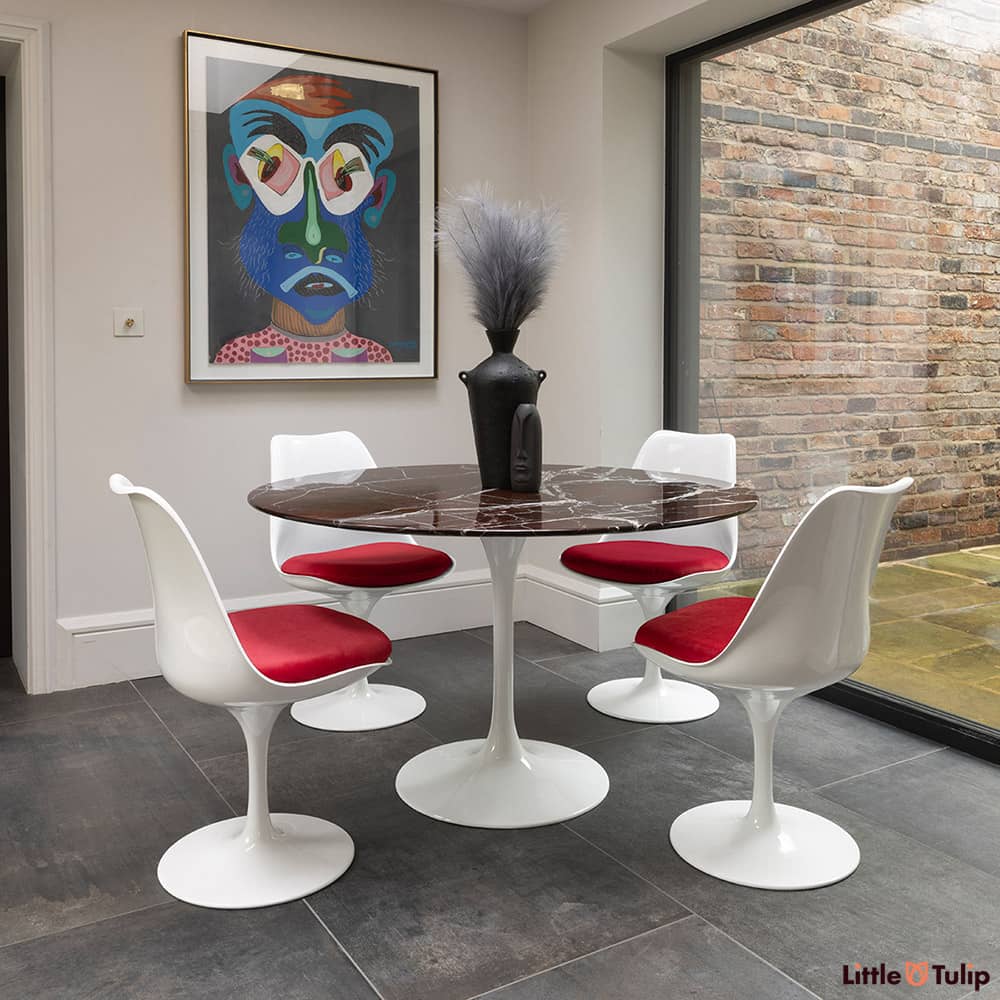 Centre shot you will find the 120 Saarinen round levanto rosso dining table and 4 Tulip side chairs with red cushion