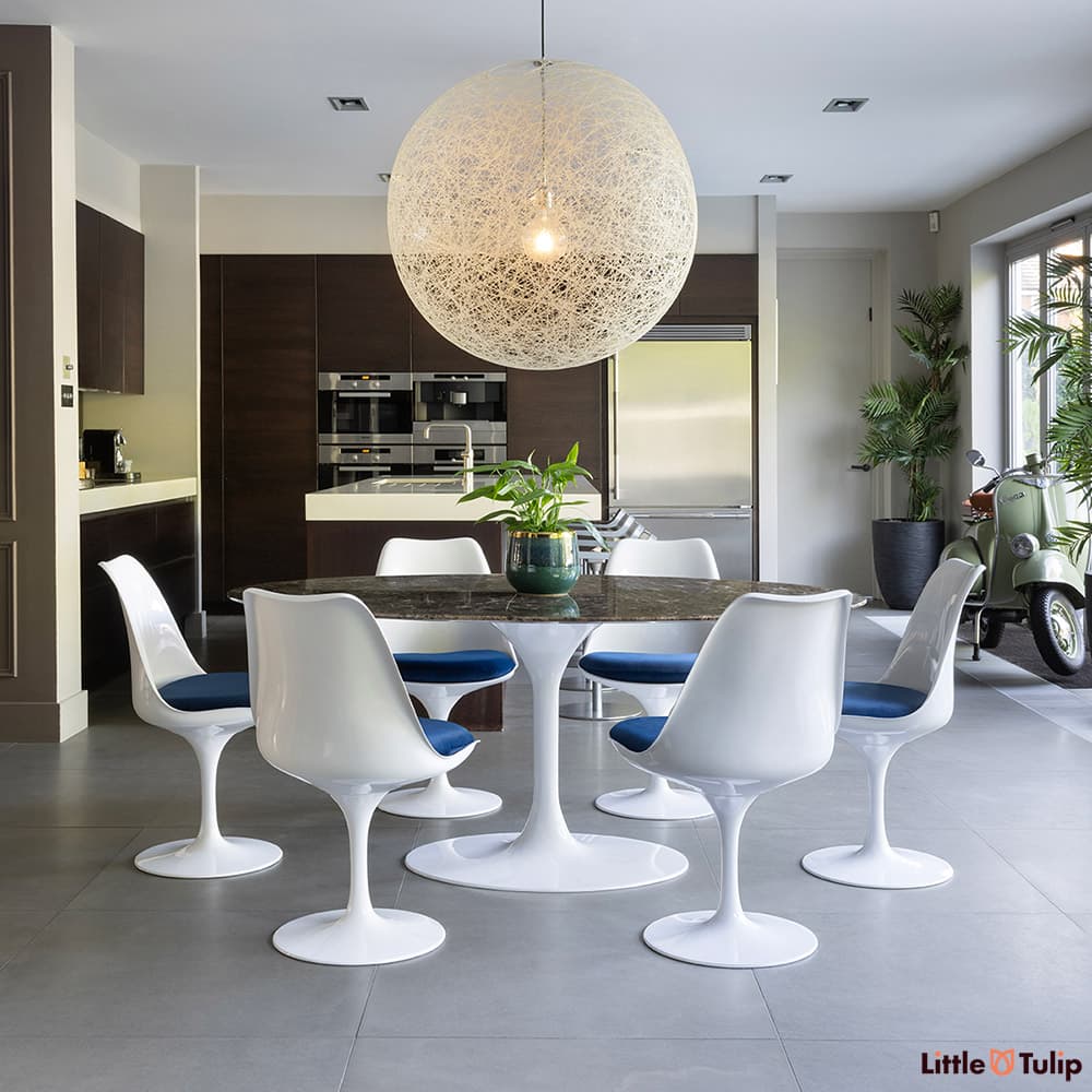 Under a large globe light, the 200 emperador tulip table and 6 chairs with blue cushions exhibit unmatched style.