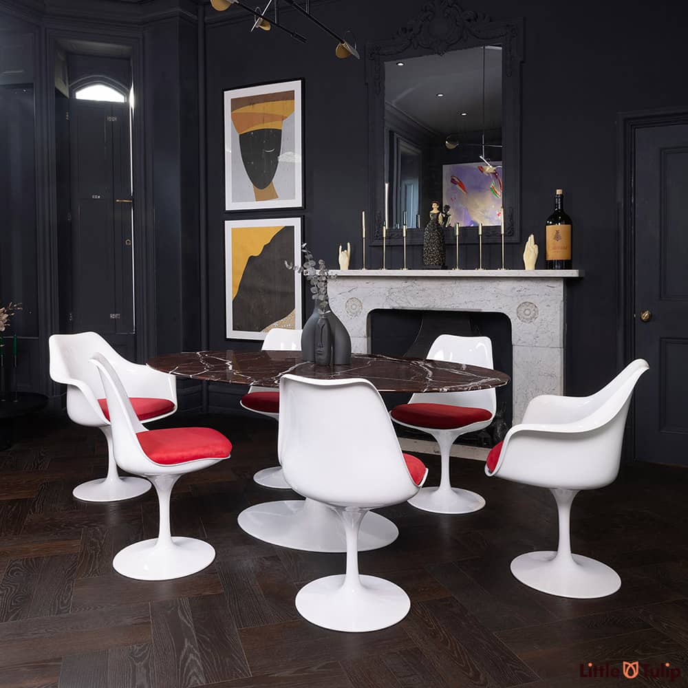 The 170 levanto rosso Saarinen oval dining table, 4 Tulip side chairs, 2 Arms, red cushions adds colour to this dark room