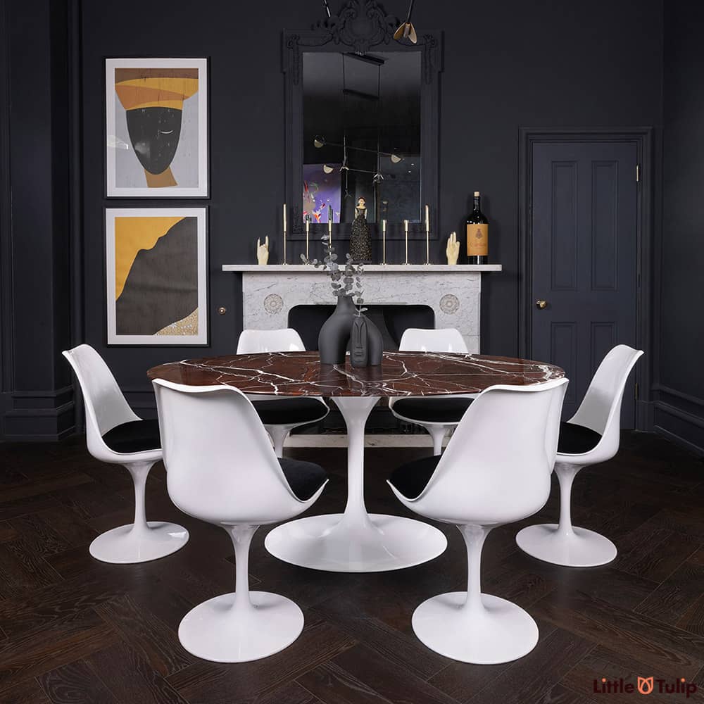 170 levanto rosso Saarinen oval dining table and 6 Tulip side chairs and black cushions add colour to this dark-themed room