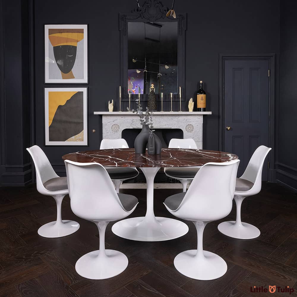 170 levanto rosso Saarinen oval dining table and 6 Tulip side chairs and grey cushions add colour to this dark-themed room