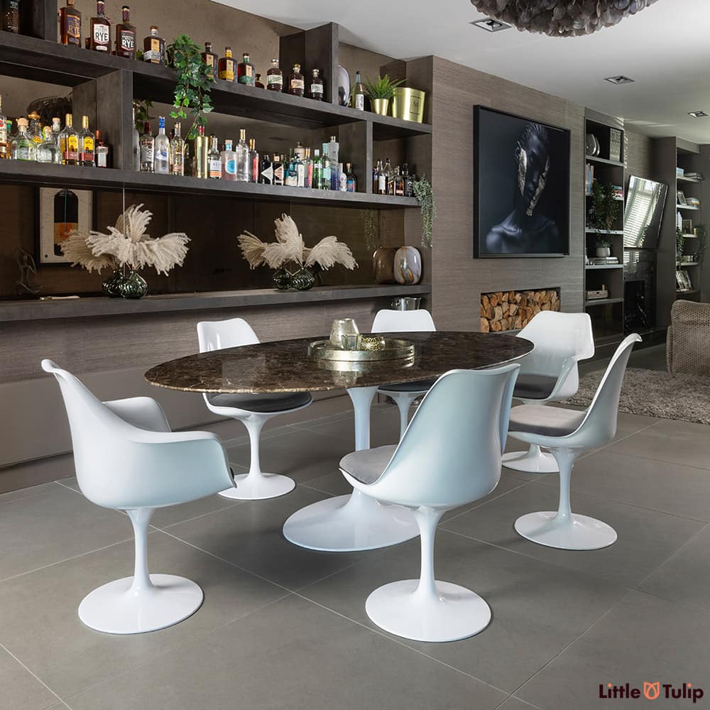 Like living and dining space, this 200 emperador tulip table, 4 sides, 2 arm chairs and grey cushions blend effortlessly