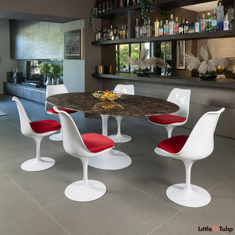 This refined 200 emperador tulip table, 6 chairs, and red cushions exudes sophistication in this elegant space.