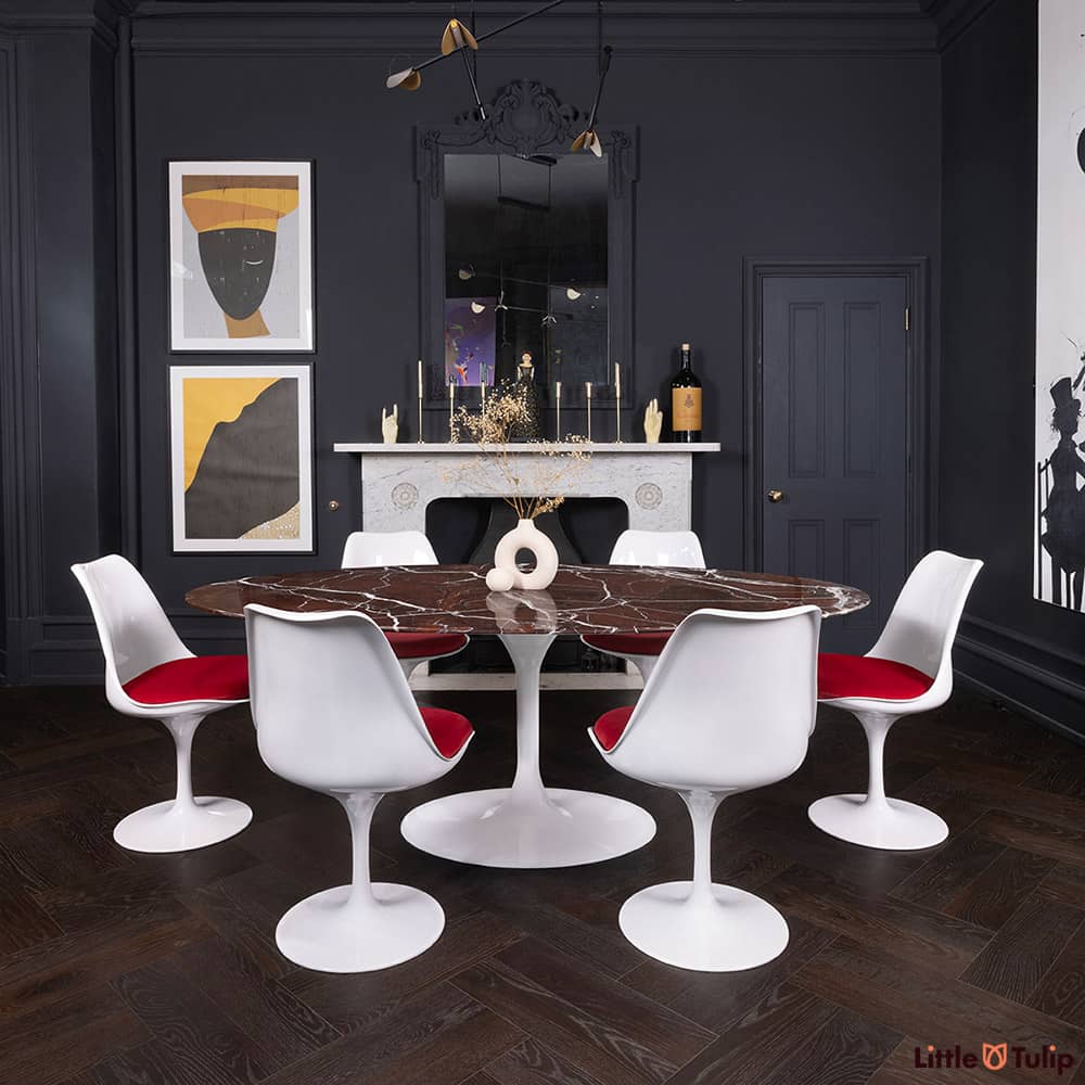 The 200 levanto rosso Saarinen oval dining table & 6 Tulip side chairs & red cushions sits with the white marble fireplace