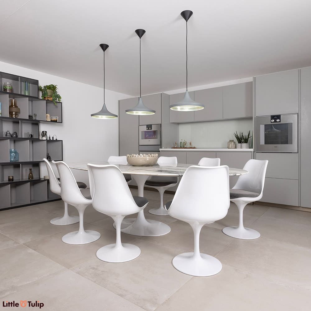 Sat on white tiles, a stunning 244 Arabescato Tulip table with 8 chairs and grey cushions is the rightful centerpiece.