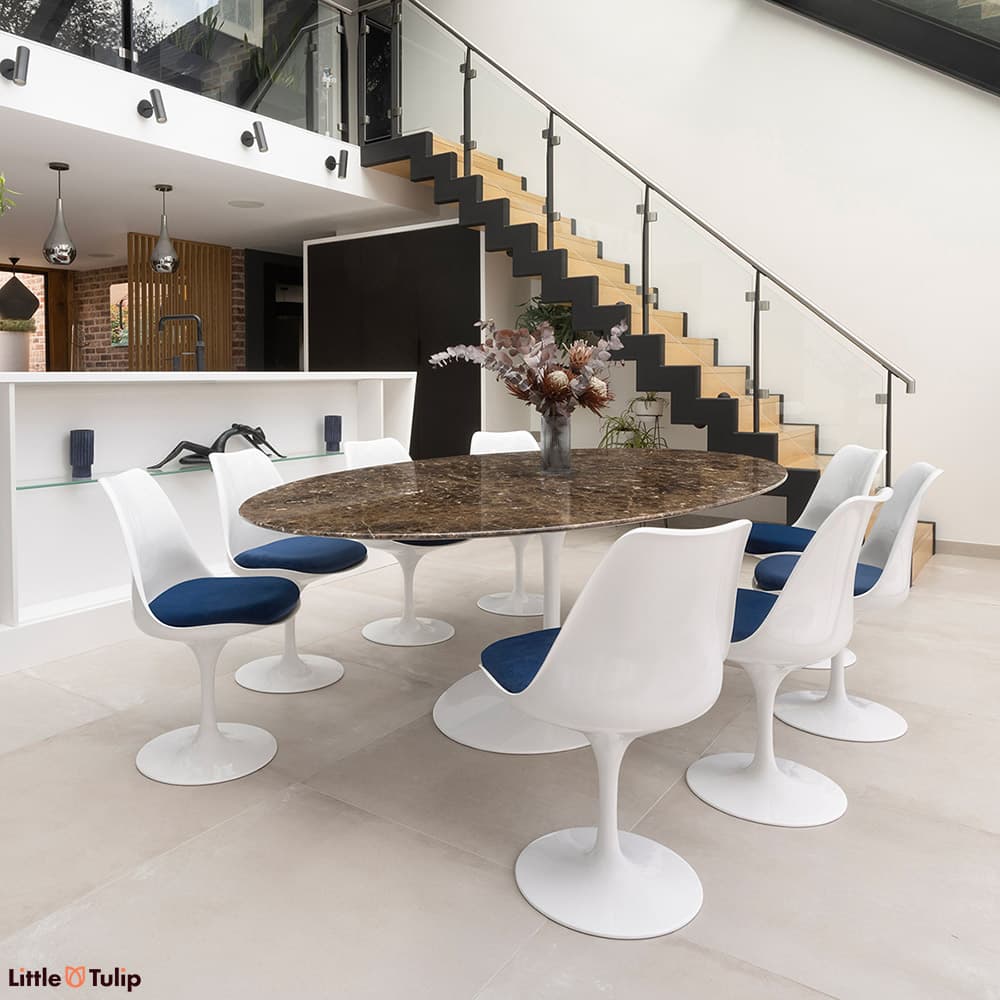 In emperador marble, the 244 tulip table with 8 side chairs and blue cushions is a stunning addition to this modern kitchen