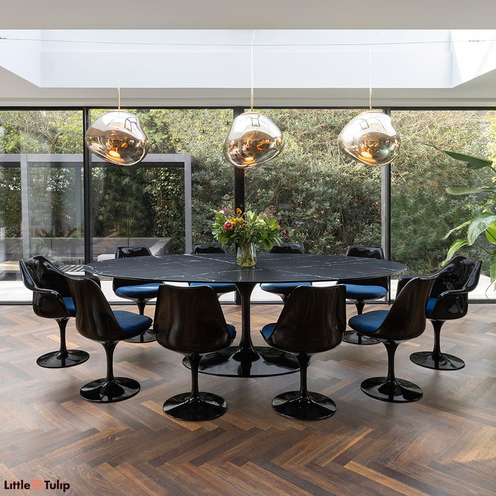 Black and blue 8 side and 2 Tulip arm chairs and a neromarquina table captured in an elegantly natural and airy dining area