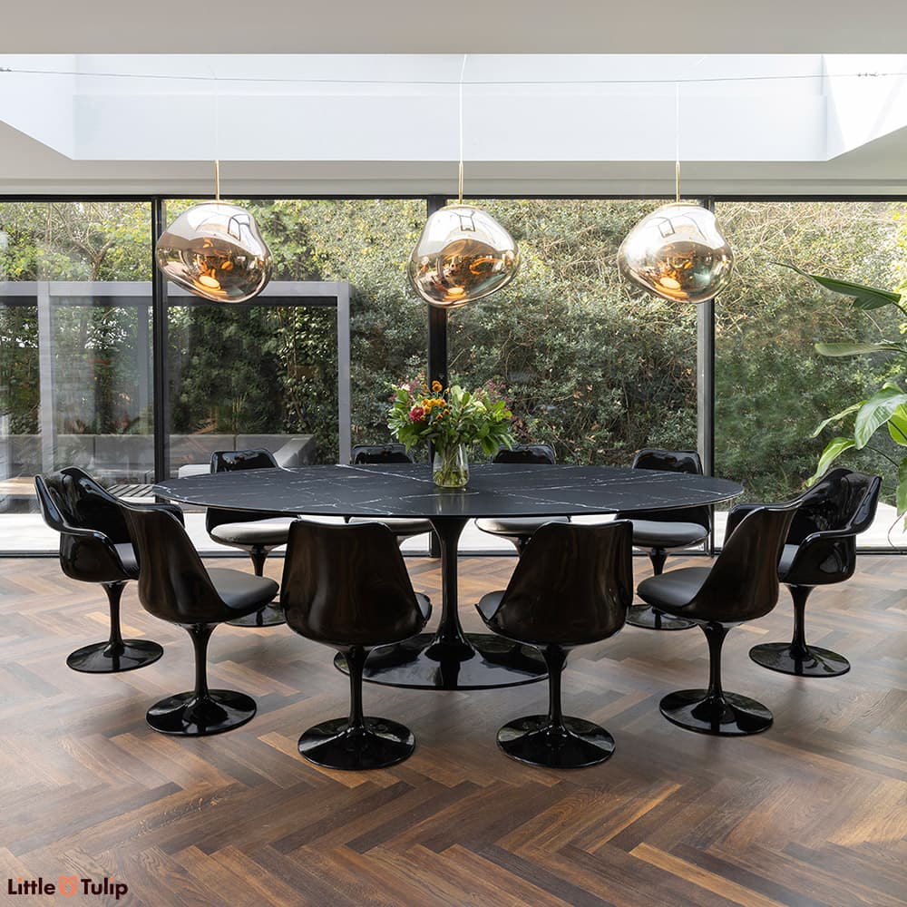 Black and grey 8 side and 2 Tulip arm chairs and a neromarquina table captured in an elegantly natural and airy dining area