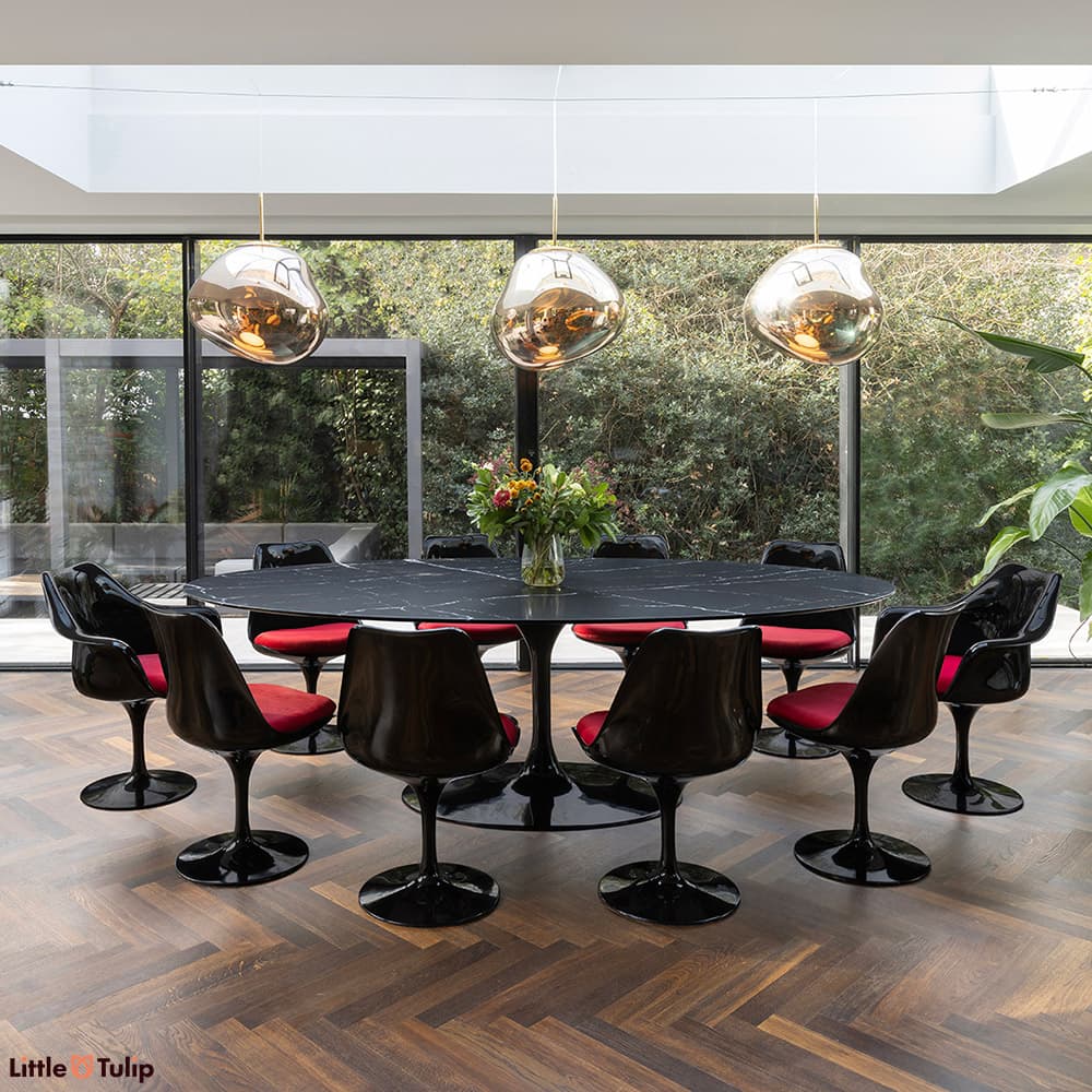Black and red 8 side and 2 Tulip arm chairs and a neromarquina table captured in an elegantly natural and airy dining area