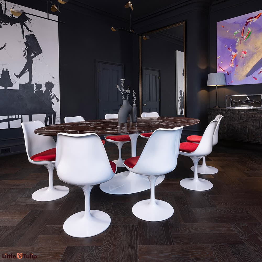 8 Tulip side chairs & red cushions surround the 244 levanto rosso Saarinen oval dining table in this modern darkened room