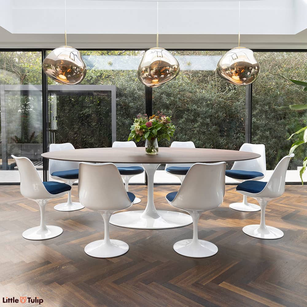 In this dining space, a walnut 244 Tulip table with 8 chairs and blue cushions seamlessly continues the natural theme.