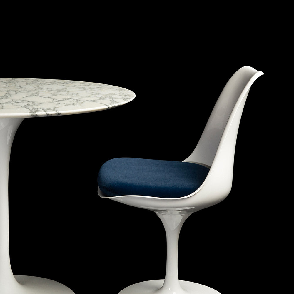 A shot that encapsulates the enigmatic beauty of a 90cm Saarinen Tulip Table, this one in Arabescato Marble with the matching side chair & blue cushion