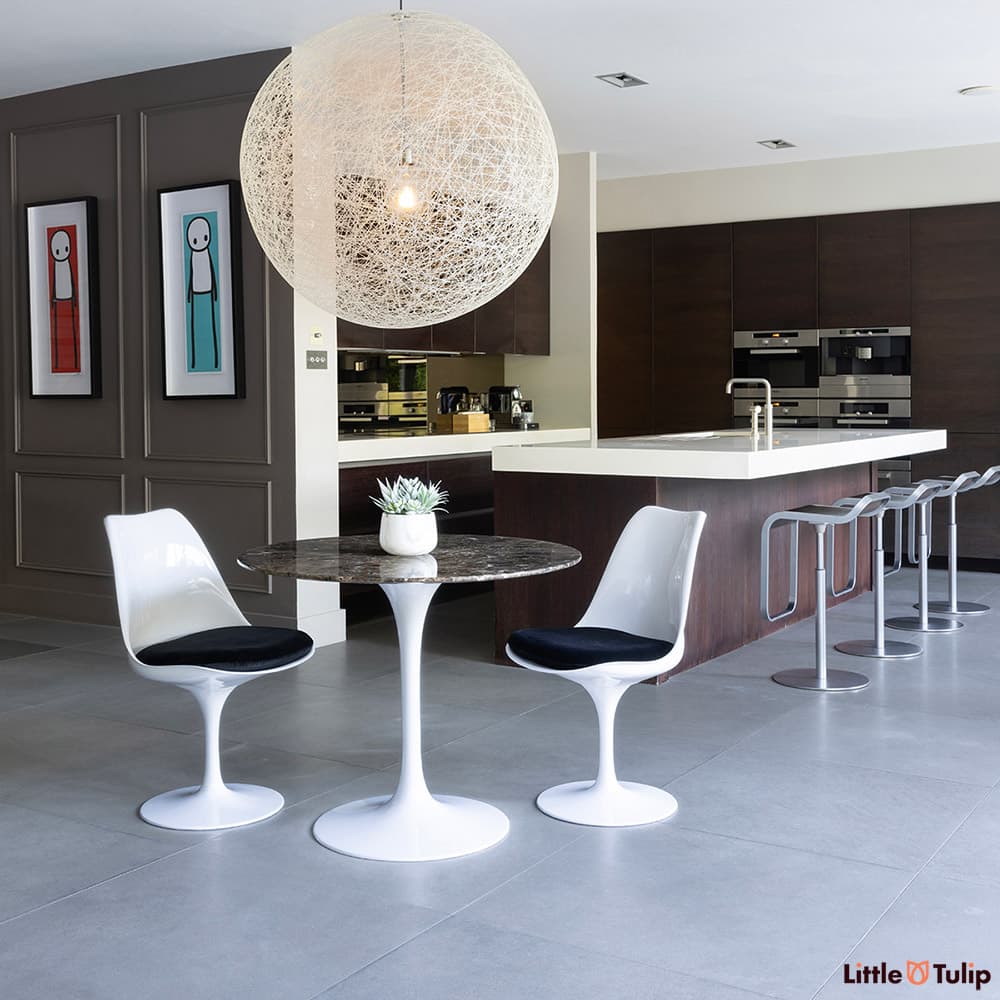 The perfect combination, 2 side chairs with black cushions around the 90cm emperador tulip table in this fresh kitchen