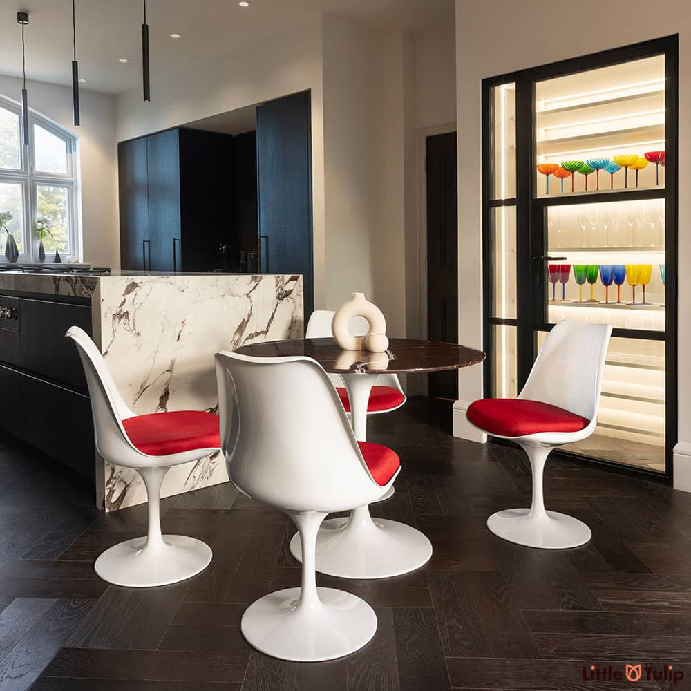 In a modern kitchen, centre stage, is the 90cm levanto rosso Saarinen dining table and 4 Tulip side chairs & red cushions
