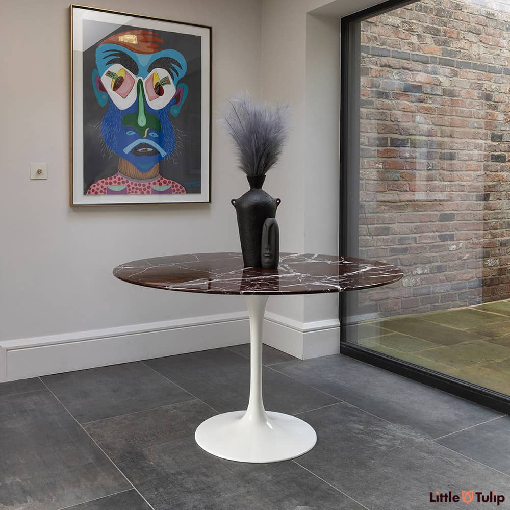 On a grey tiled floor, this majestic levanto rosso Saarinen 120cm dining table compliments it perfectly.