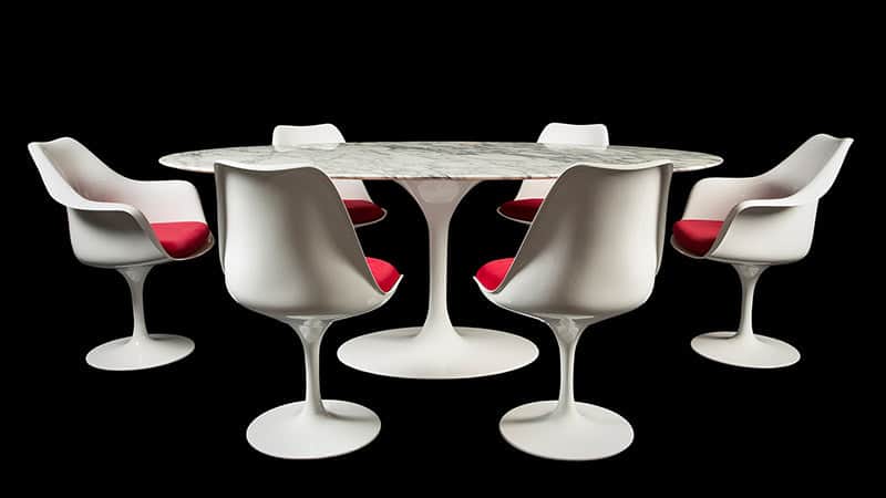 A category image for the home page for dining sets featuring an Eero Saarinen Tulip Table in Arabescato Marble alongside Tulip chairs with red cushions