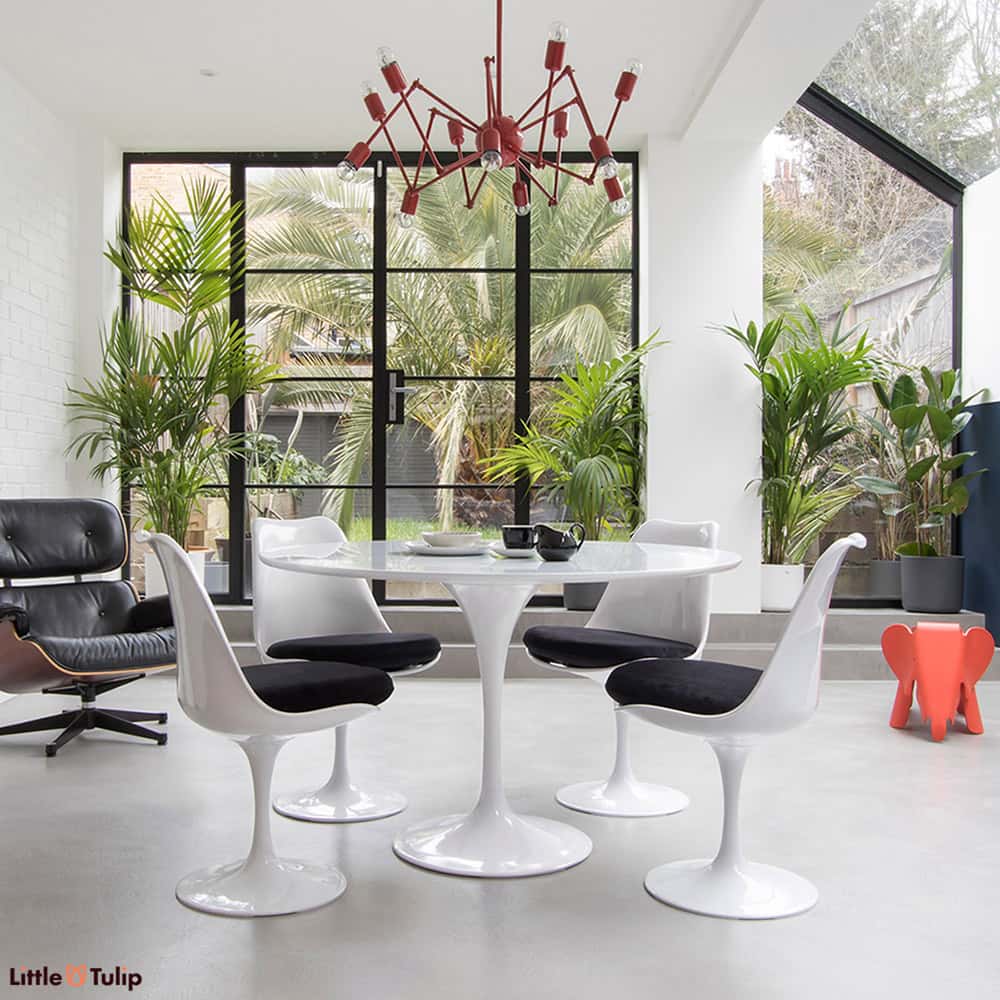 The beautiful sheer white sheen of the original classic 120 cm Tulip Table is perfect with a group of 4 Tulip Side Chairs with soft velvety black cushions