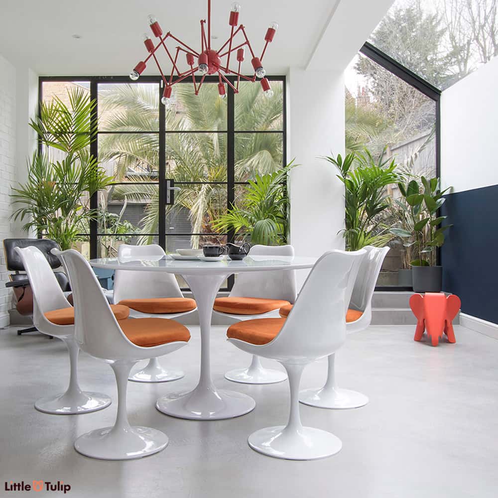 Simplicity personified with the Classic White Saarinen Tulip Table 120 cm matched together with the Tulip Side Chairs & finished with soft orange cushions