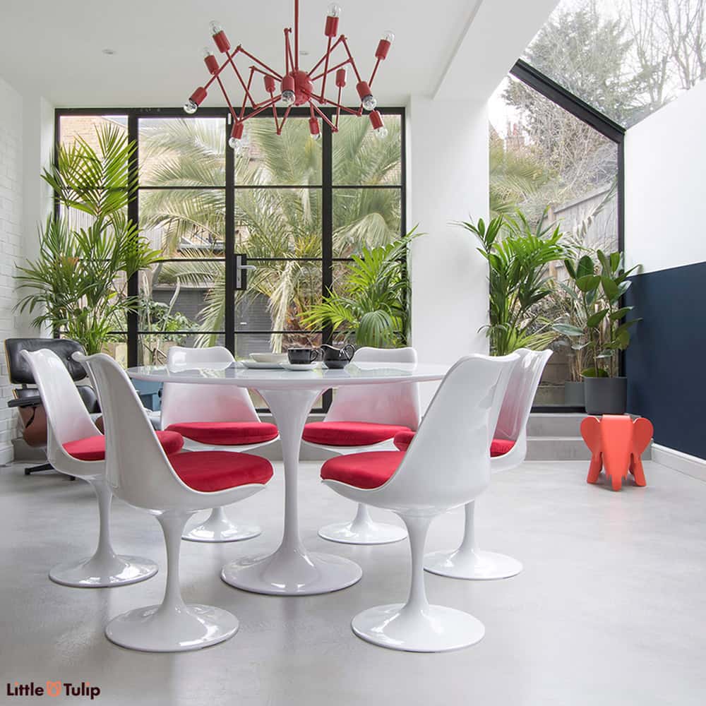 Simplicity personified with the Classic White Saarinen Tulip Table 120 cm matched together with the Tulip Side Chairs & finished with soft red cushions