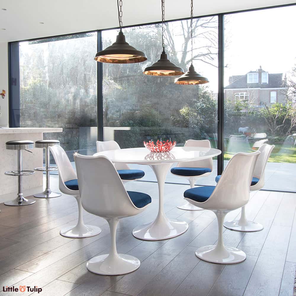 A 170 cm Oval Tulip Table in the classic white gives a room more light, more visual space & coupled with 6 Tulip chairs in blue fabric, real theatre too