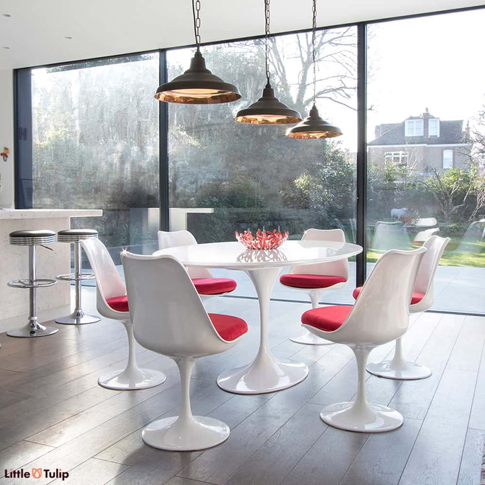 A 170 cm Oval Tulip Table in the classic white gives a room more light, more visual space & coupled with 6 Tulip chairs in red fabric, real theatre too