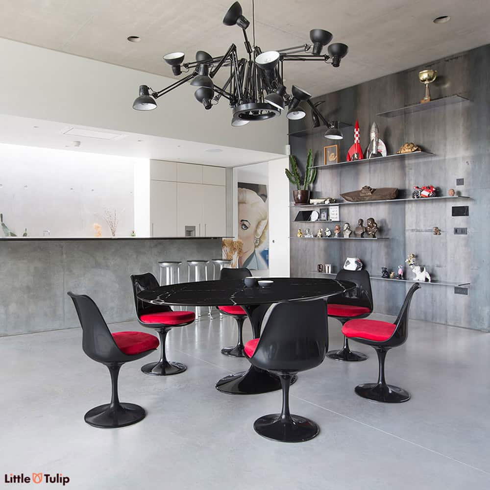 The ultimate alternative dining room style featuring the black Nero Marquina Tulip Oval table & 6 black Tulip side chairs with a red hint cushions
