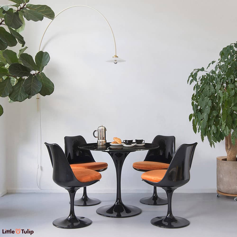We often want something a little bit different, is there anything better than the 90 cm Tulip table & chairs in black marble with lively orange cushions