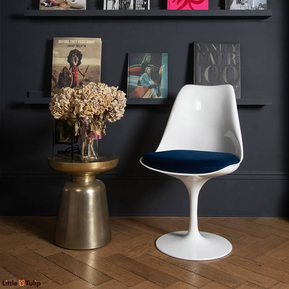 How it contrasts! The white tones of the original timeless Tulip Side Chair, an ocean blue velvet cushion & the dark interior of the room it stands in