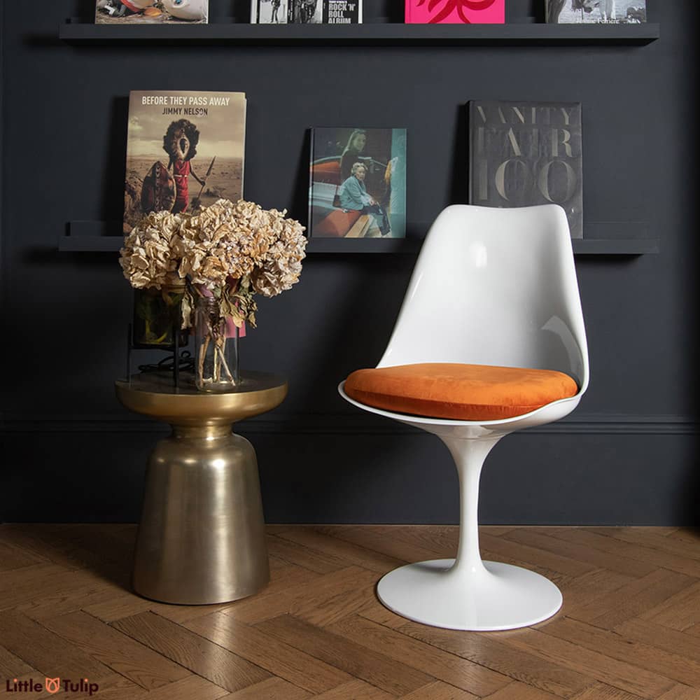 How it contrasts! The white tones of the original timeless Tulip Side Chair, a flame orange velvet cushion & the dark interior of the room it stands in