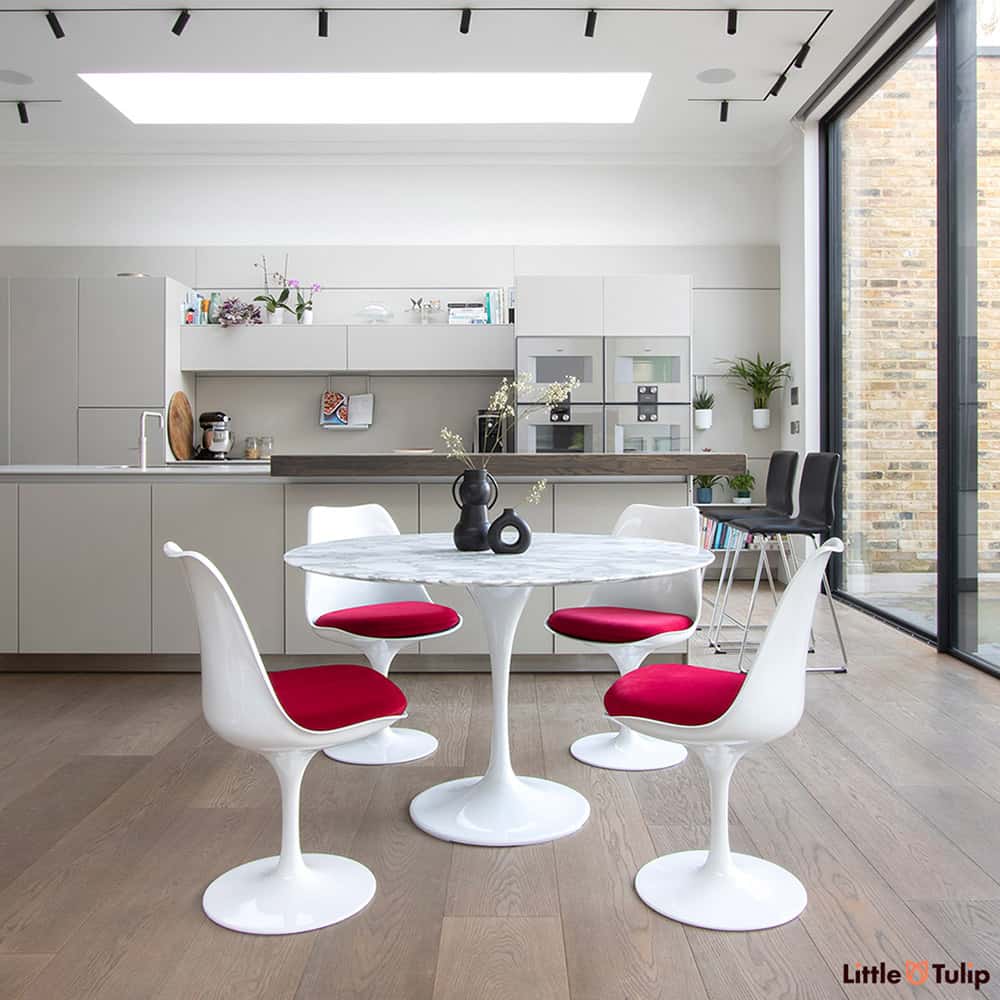 A beautifully finished modern kitchen spectacularly styled with a 120 cm Tulip Table in Arabescato Marble & 4 side chairs with chili red cushions